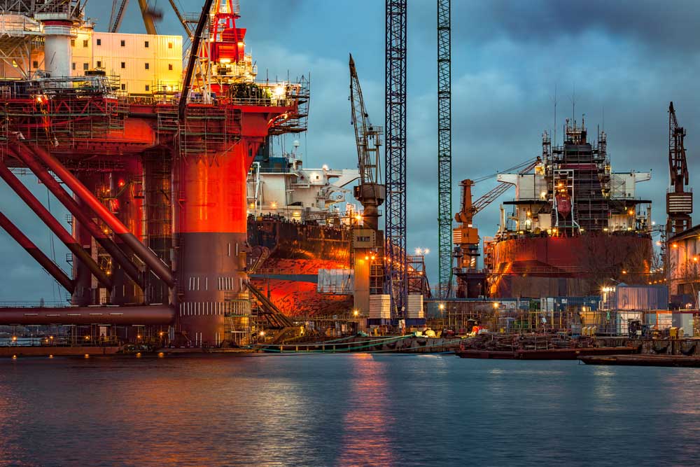 Oil rig in dock with offshore supply vessels